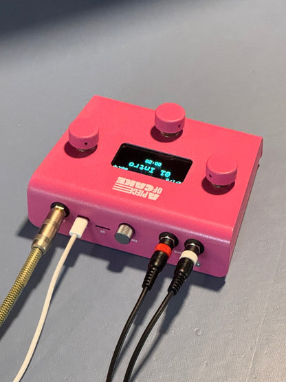 Pink A piece of cake backing track player, angled view of the back panel with click output, USB-C and stereo output cables connected