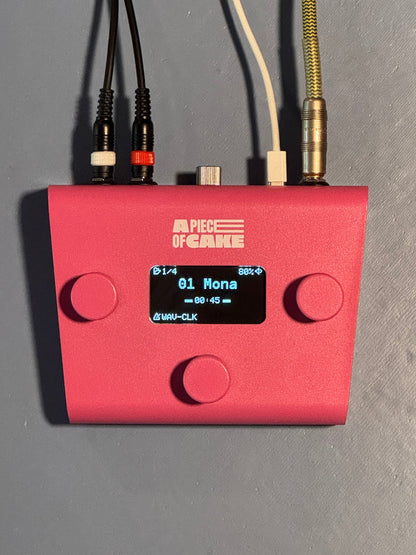 Pink A piece of cake backing track player from above, cables plugged in, screen showing a song with a WAV click track loaded