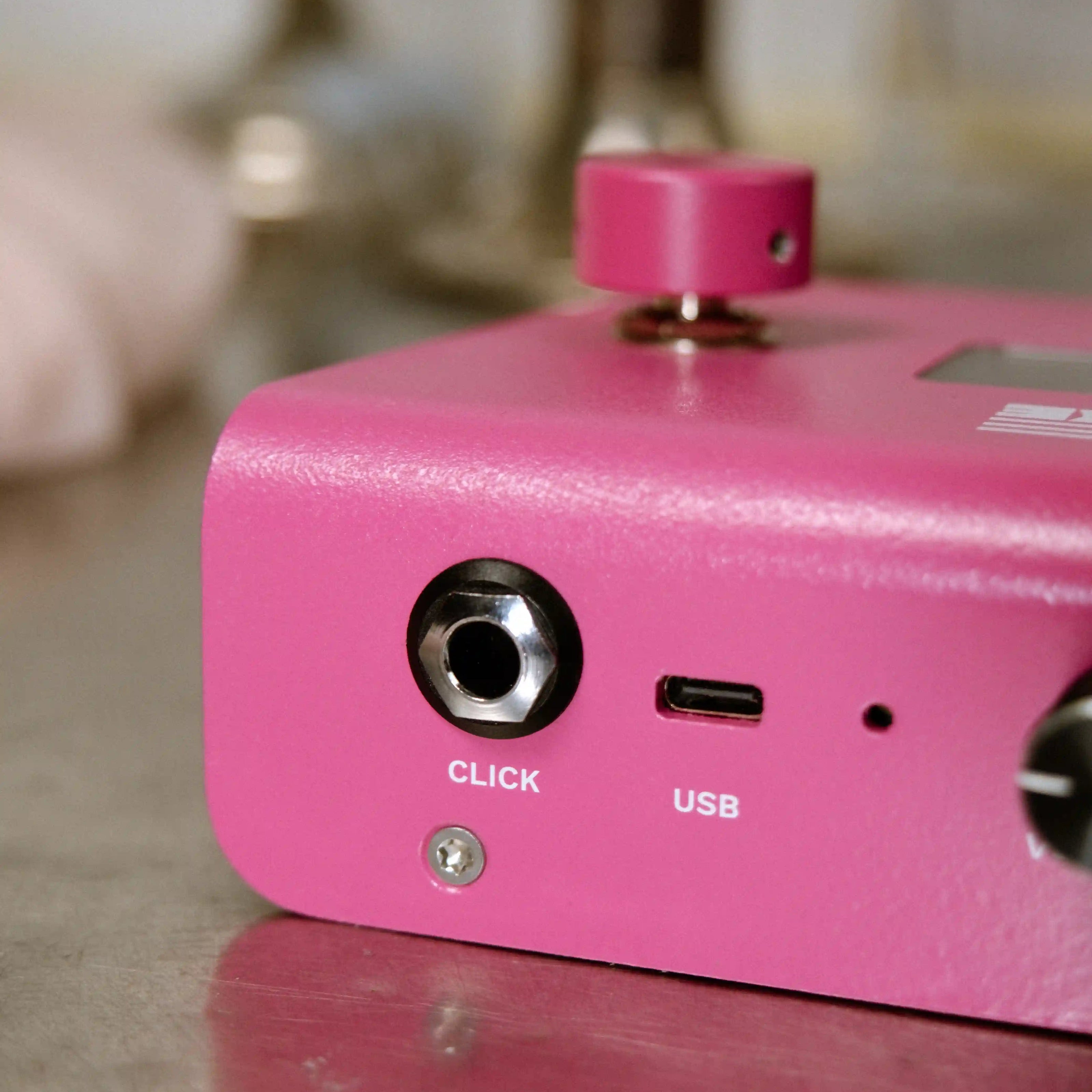 Close-up of a pink electronic A piece of cake device with ports on a reflective surface