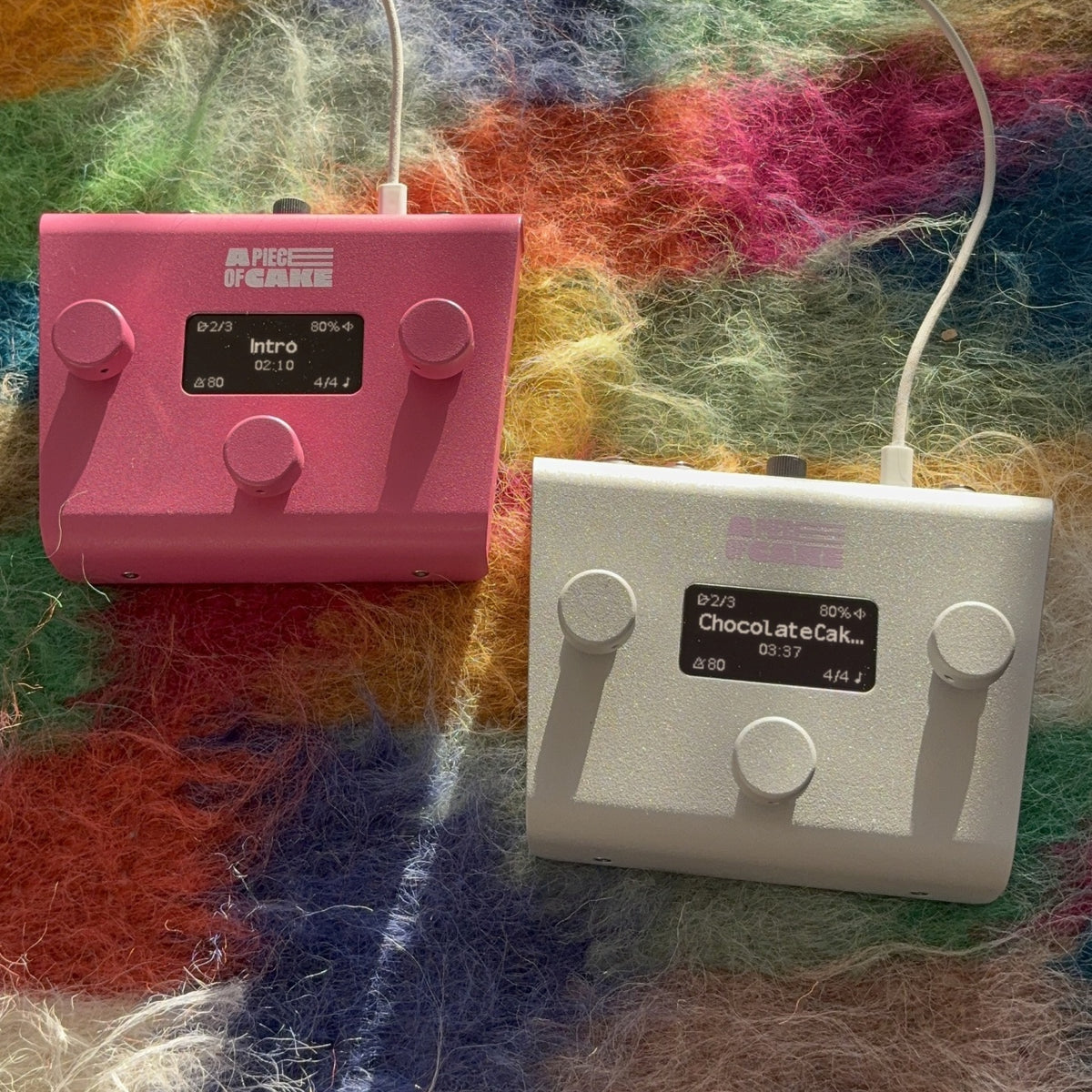 A piece of cake backing track pedal in pink and silver on a colourful rug